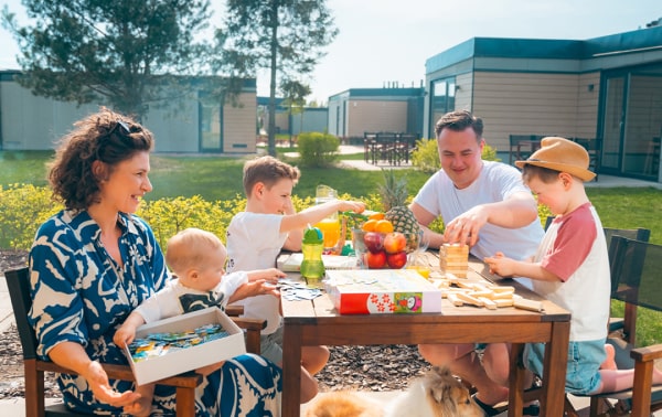 Szczęśliwa rodzina cieszy się piknikiem z jedzeniem i napojami w słonecznym plenerze.